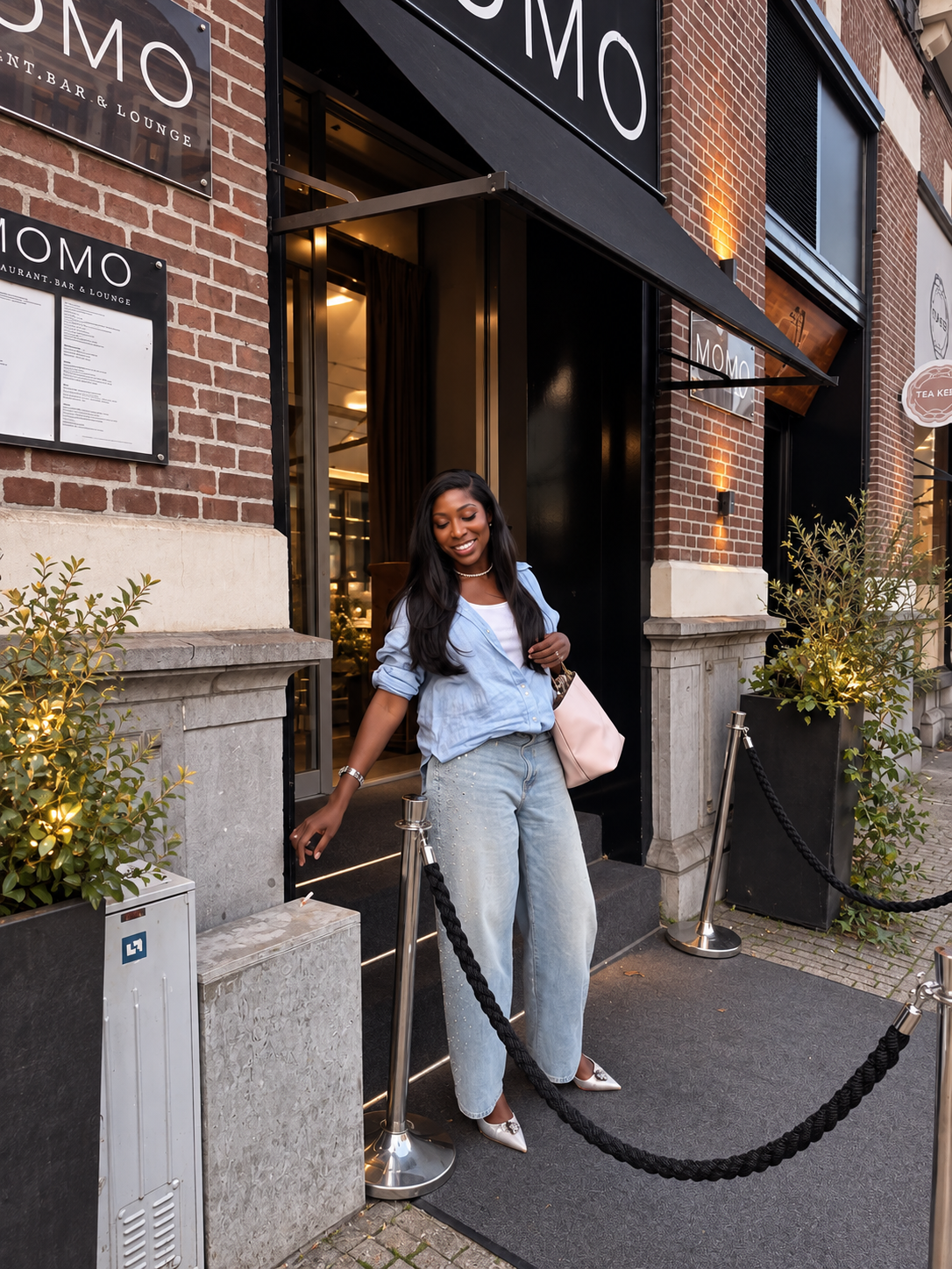 Vanessa stepping out of MOMO restaurant in Amsterdam in a blue shirt and jeans